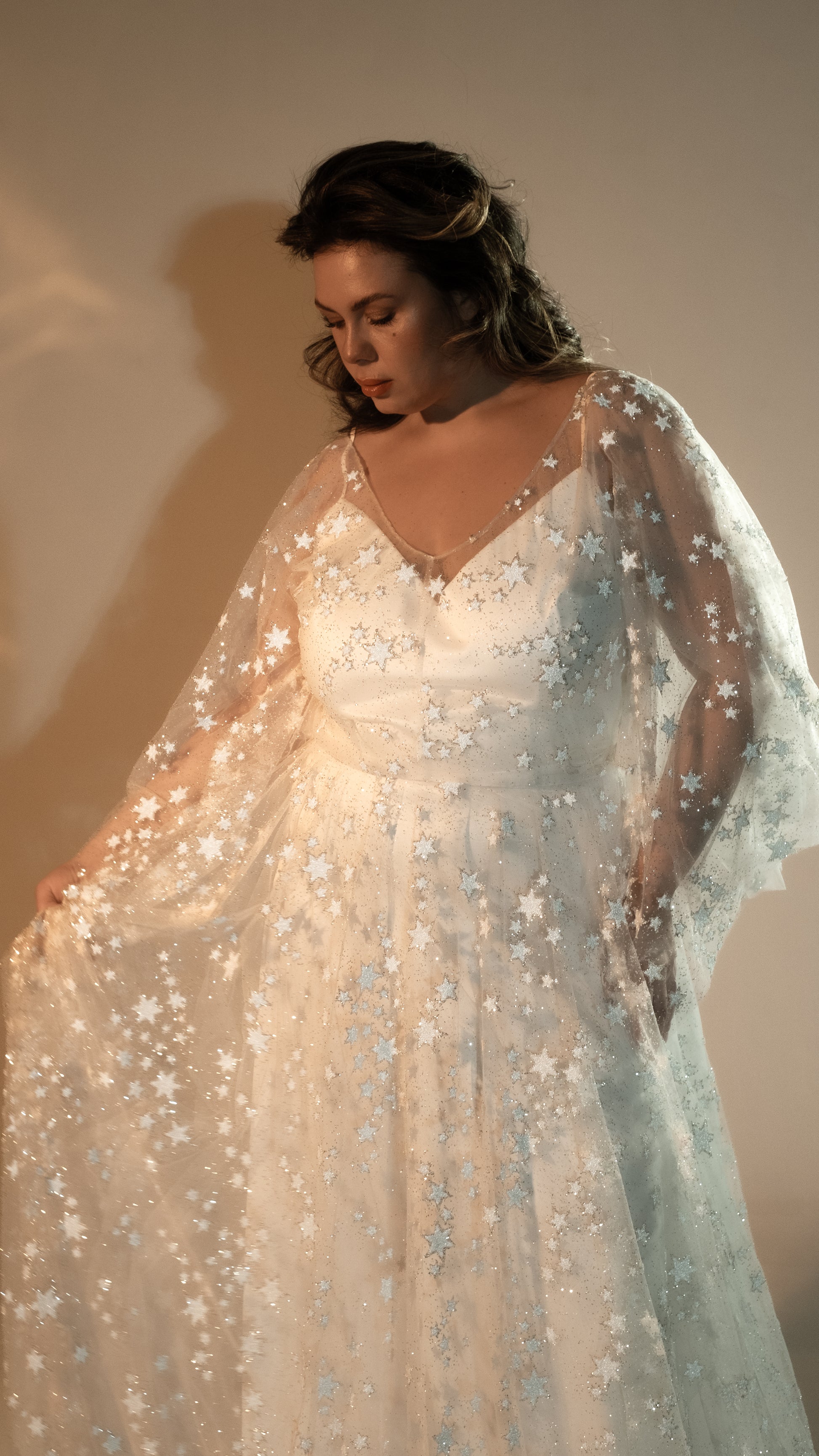 Two-piece ivory wedding dress with glowing star lace overlay plus size bride wearing romantic gown with veil and zodiac stars