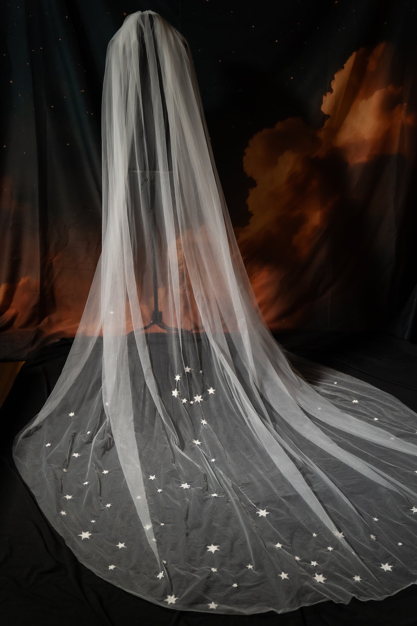 White wedding veil with star-shaped lace details against a dark background