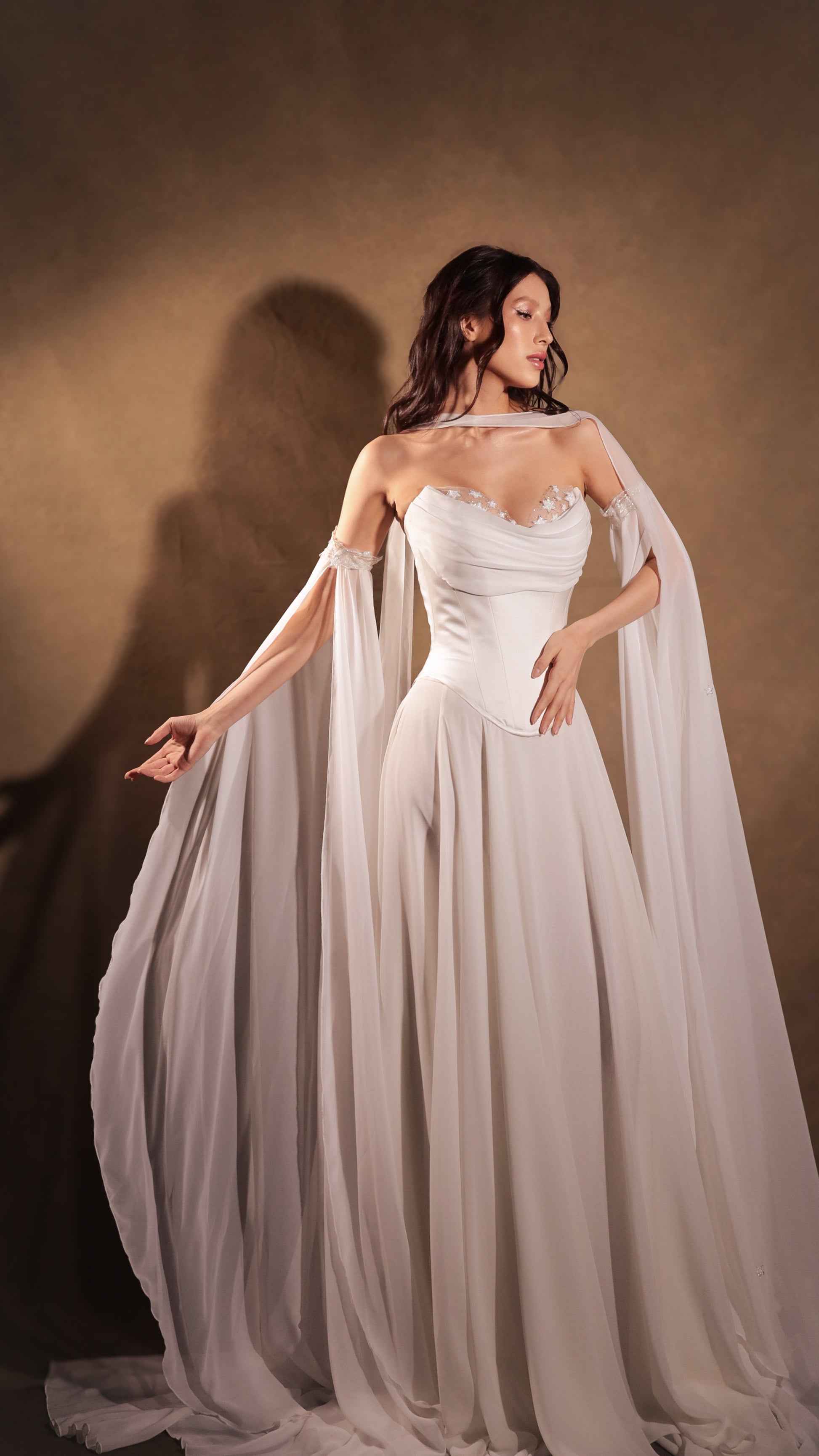 Venus bridal ensemble featuring ivory satin corset, A-line chiffon skirt with train, and starry Feyre Sleeves by Boom Blush. Venus bridal ensemble featuring ivory satin corset, A-line chiffon skirt with train, and starry Feyre Sleeves by Boom Blush.